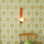 Skipper wall light in transparent coral in front of patterned wallpaper