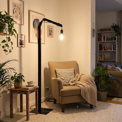 Lámpara de pie «Taiseki» junto a un cómodo sillón con una manta mullida en el salón